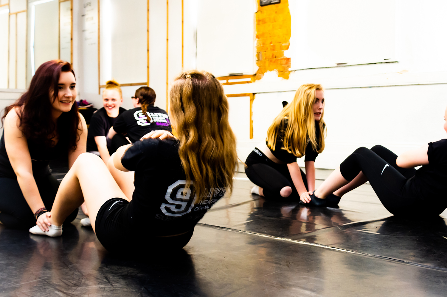 Nine Lives Theatre Company students in the middle of a workout.