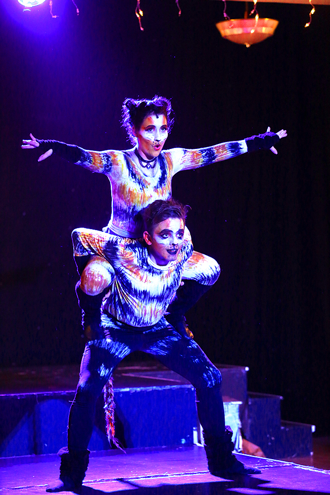 Nine Lives dancers in full costume, showing off a lift mid show.